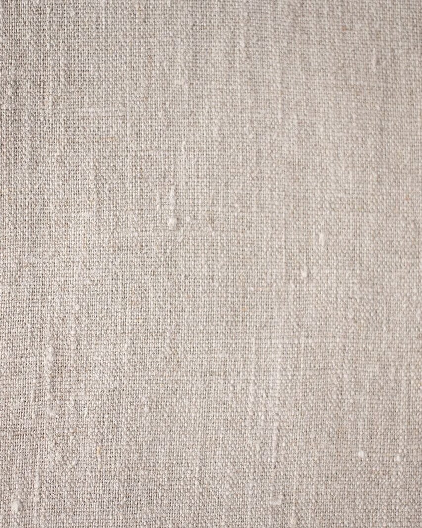 A close view of a plain-weave linen cloth in a natural flax colour